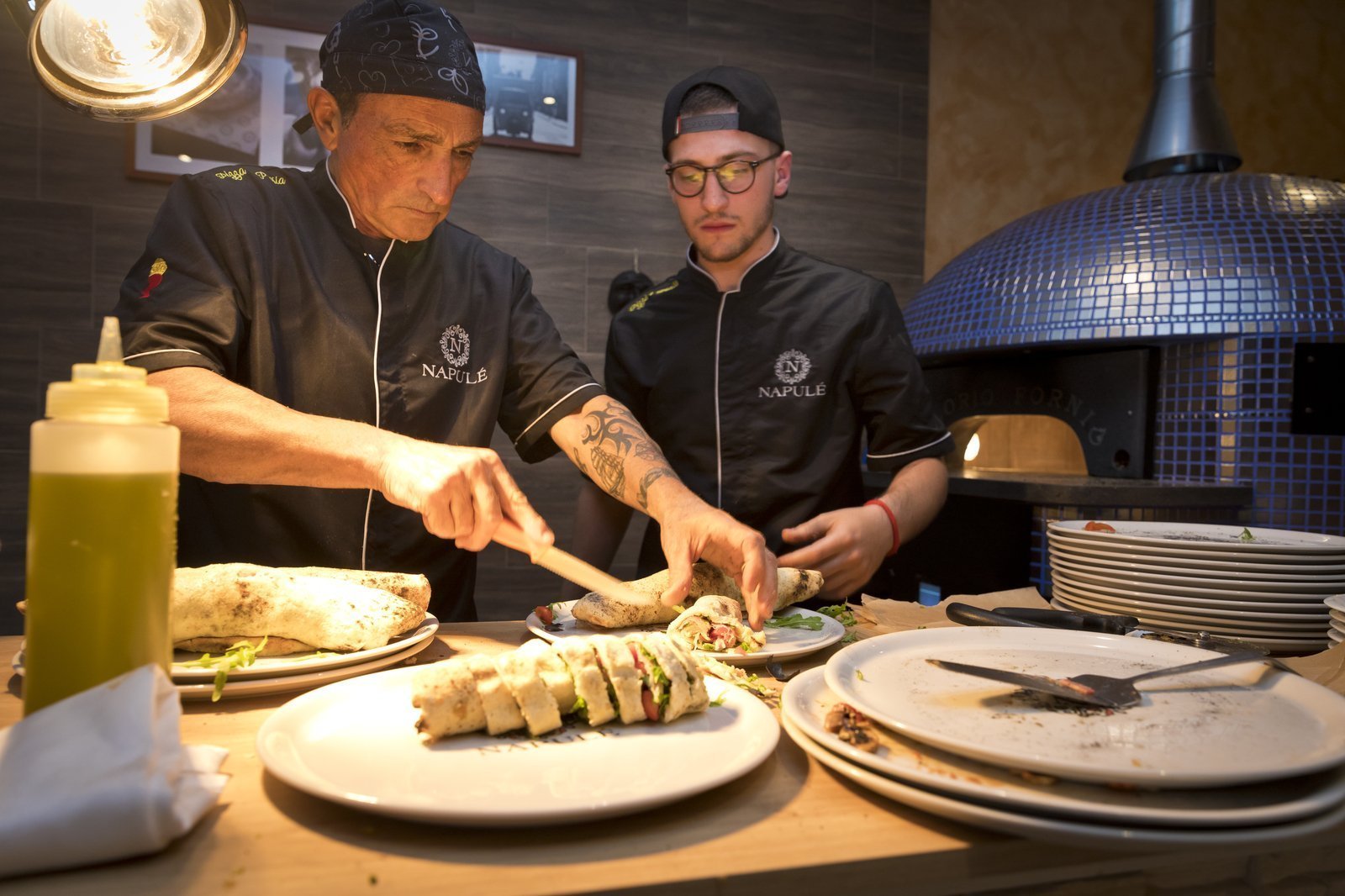 Pizzaiolo am Pizza machen im Restaurant Napule Pizzaiolo am italienische vorspeisen frisch am vorbereiten