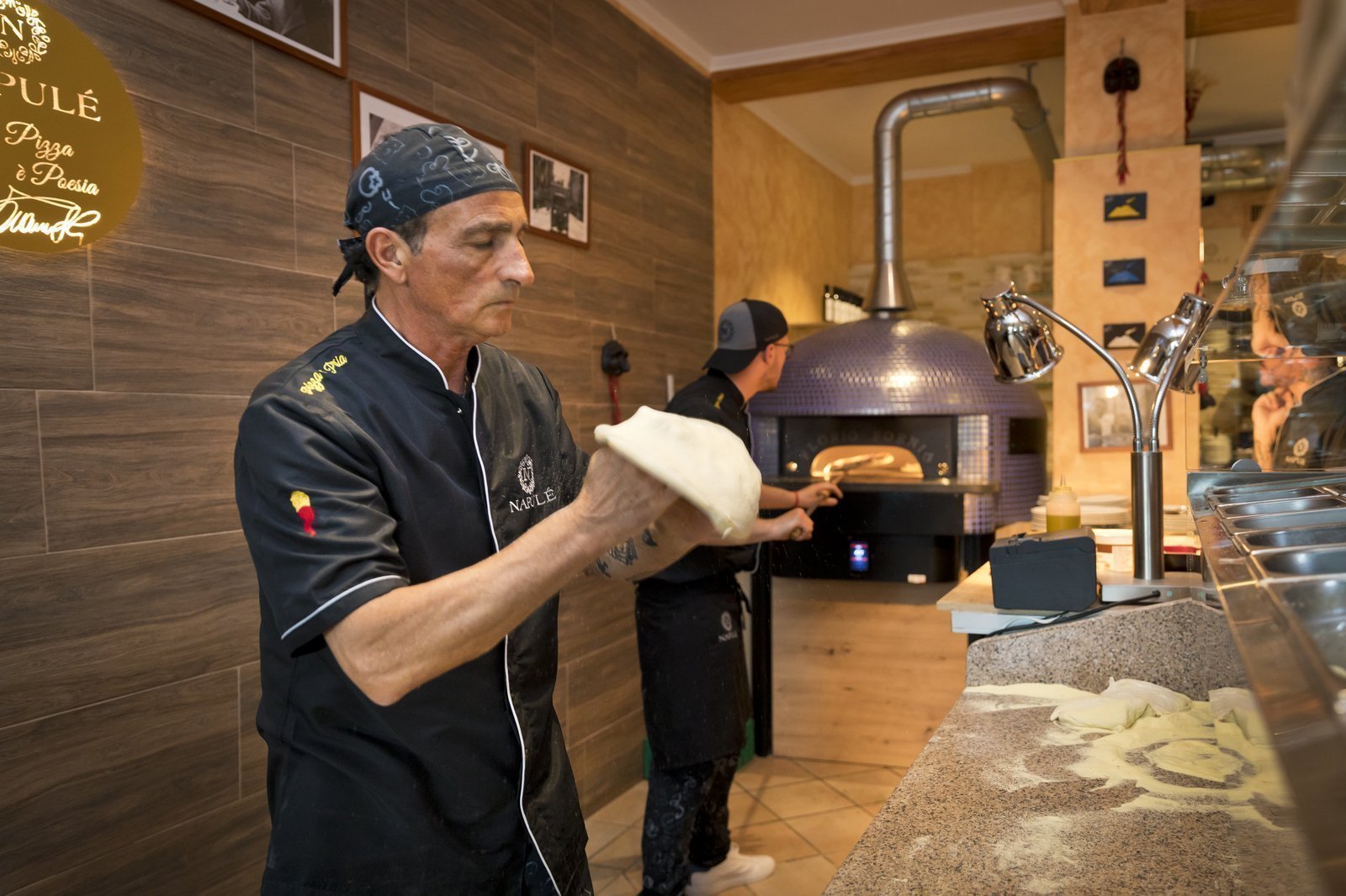 Pizzeria Napule in Locarno Pizzaiol am handgemachten Pizzateigg werfen in der besten Pizzeria in Locarno