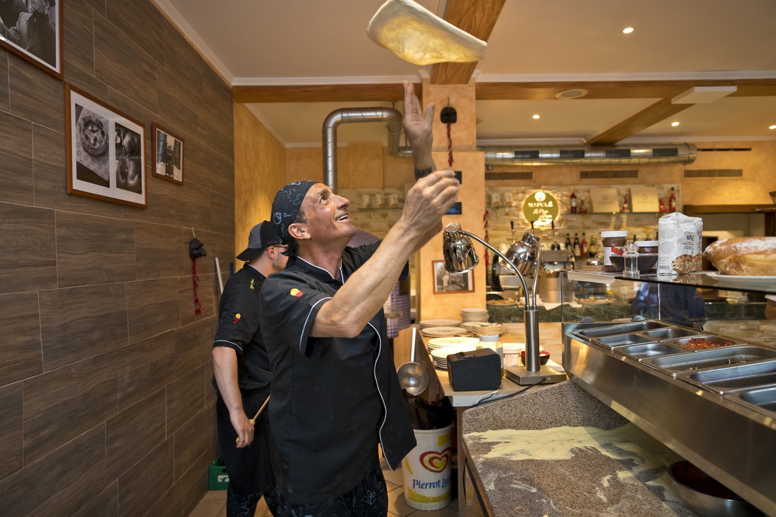 Italienischer Pizzaiolo aus Neapel Italienischer Pizzaiolo am Pizza machen in Locarno in einer offene Italienischen Küche